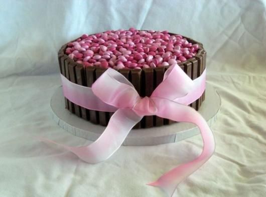 A fita rosa combina com os confeitos do bolo